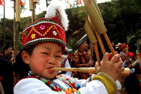 A brightly-attired boy of the ethnic Miao group flutes and dances during a frolic of Luseng (a reed-pipe Bamboo-cluster flute) dance of hall-stepping, a gala drawing many little boys of the ethnic Miao group to bring forth their skillful Luseng flute dancing, at Sirong Township, Rongshui Miao Autonomous County, southwest China's Guangxi Zhuang Autonomous Region, on January 29, 2009. 