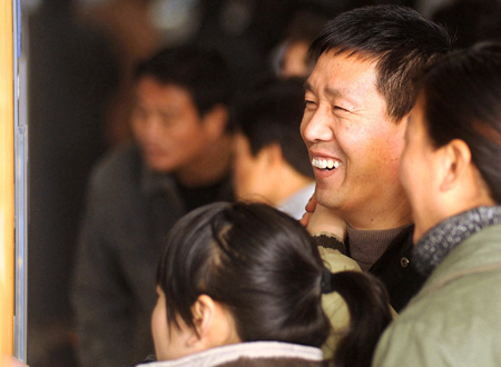 A migrant worker smiles after finding a job at the human resource market in Hangzhou, capital of east China's Zhejiang Province, on January 31, 2009. A propose signed by 200 local enterprises at the beginning of the New Year calls for no layoffs and no salary cut in 2009 that encouraged the migrant workers to come back to towns after the Spring Festival holidays. 