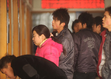 Migrant workers look for job information at the human resource market in Hangzhou, capital of east China's Zhejiang Province, on January 31, 2009. A propose signed by 200 local enterprises at the beginning of the New Year calls for no layoffs and no salary cut in 2009 that encouraged the migrant workers to come back to towns after the Spring Festival holidays. [Xinhua]