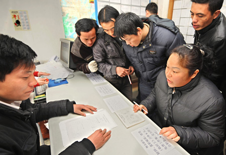 A migrant worker(1st, R) asks for job information at the human resource market in Hangzhou, capital of east China's Zhejiang Province, on January 31, 2009.