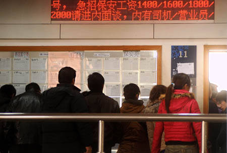 Migrant workers look for job information at the human resource market in Hangzhou, capital of east China's Zhejiang Province, on January 31, 2009.