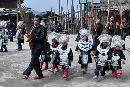 Children dressed in the costume of Miao ethnic group perform dance in the Zhanliu Village of Jianhe County, southwest China's Guizhou Province, on January 31, 2009.