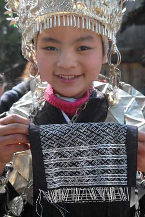 A girl of Miao ethnic group shows her embroidery in the Zhanliu Village of Jianhe County, southwest China's Guizhou Province, on January 31, 2009.