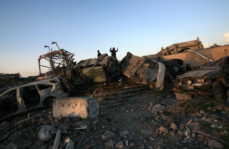 Security members of the Palestinian Islamic Resistance Movement (Hamas) inspects the debris of the presidential office in Gaza City, Jan. 31, 2009. The compound, used to be the residence of late Palestinian leader Yasser Arafat, was razed to the ground during Israel's 22-day operation of Cast Lead against the Gaza Strip.