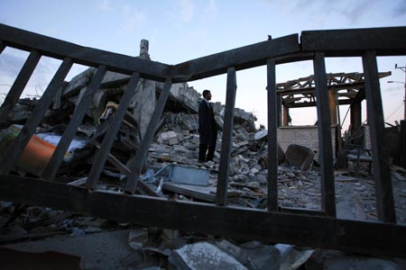 A security member of the Palestinian Islamic Resistance Movement (Hamas) inspects the debris of the presidential office in Gaza City, Jan. 31, 2009. The compound, used to be the residence of late Palestinian leader Yasser Arafat, was razed to the ground during Israel's 22-day operation of Cast Lead against the Gaza Strip.