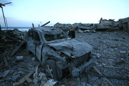 A security member of the Palestinian Islamic Resistance Movement (Hamas) inspects the debris of the presidential office in Gaza City, Jan. 31, 2009. The compound, used to be the residence of late Palestinian leader Yasser Arafat, was razed to the ground during Israel's 22-day operation of Cast Lead against the Gaza Strip.