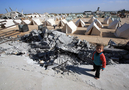 A child stands near tents set up by Palestinians who lost their homes during the 22-day Israeli offensive in Jabalia, northern Gaza Strip, on January 31, 2009.