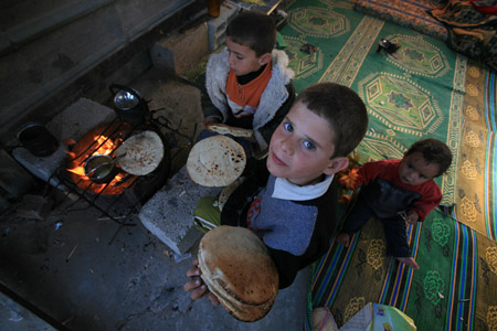 Palestinian children who lost their homes during the 22-day Israeli offensive bake cakes in a tent in Jabalia, northern Gaza Strip, on January 31, 2009.