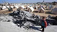 A child stands near tents set up by Palestinians who lost their homes during the 22-day Israeli offensive in Jabalia, northern Gaza Strip, on January 31, 2009.