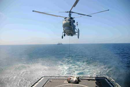 A helicopter unloads supplies onto the deck of Chinese destroyer Wuhan sailing in the Gulf of Aden, on January 31, 2009. The destroyer Wuhan sent a helicopter to fetch supplies from a Chinese merchant ship Xin Fei Zhou on Saturday, which was the first vertical replenishment (VERTREP) done by the Chinese naval fleet since it began its escort mission against pirates on January 6, 2009.