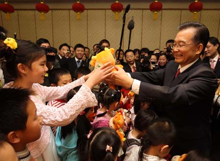 Chinese Premier Wen Jiabao (R) presents new year gifts to children of staff members of the Chinese Embassy to Britain as he visits the Chinese Embassy to Britain in London, Britain, Feb. 1, 2009. Wen is on a three-day official visit to Britain, the last leg of his week-long European tour. 
