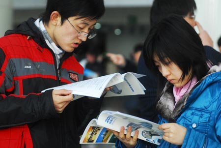 Jobseekers browse brochure of job information at a job fair held in Yantai, east China's Shandong Province, on February 3, 2009.