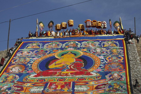 Ethnic Tibetan monks display a giant 'thangka', a sacred painting on cloth on a hill outside a monastery in Tongren, northwest China's Qinghai Province on Monday, on February 2, 2009. Local Tibetan monks and pilgrims gather to celebrate Monlam, or Great Prayer Festival, one of the most important festivals in Tibetan Buddhism.