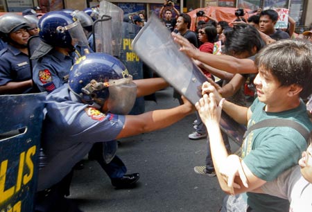 Riot policemen use their shields to push back protestors, mostly students, during a rally outside the US embassy in Manila, Philippines, on February 3, 2009.