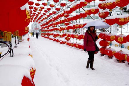 A woman walks in snow in Altay, northwest China's Xinjiang Uygur Autonomous Region, on February 3, 2009. A heavy snowfall hit Altay area Tuesday, causing inconvenience to traffic.