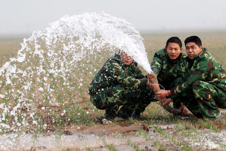 People irrigate the wheat field at Xiaolu Village in Yuzhou, a city in central China's Henan Province, on February 4, 2009. Henan, China's major grain producer, issued a red alert for drought on January 29. The provincial meteorological bureau said the drought is the worst since 1951. The drought has affected 63 percent of the province's 5.26 million hectares of wheat.