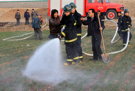 Firemen help irrigate the wheat field in Luoyang, a city in central China's Henan Province, on February 4, 2009. Henan, China's major grain producer, issued a red alert for drought on January 29. The provincial meteorological bureau said the drought is the worst since 1951. The drought has affected 63 percent of the province's 5.26 million hectares of wheat.