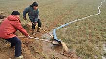 People irrigate the wheat field at Xindian Village in Luoyang, a city in central China's Henan Province, on January 4, 2009. Drought has hit most of Henan Province, one of China's key wheat producing regions, due to lack of rainfall since last October.