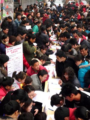 People search for job information at the job fair for migrant workers held in Huaiyuan County, east China's Anhui Province, on February 4, 2009. Over 3,000 job vacancies of 120 local enterprises were provided to migrant workers at the job fair. 