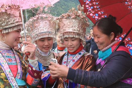 Girls of Miao ethnic group check pictures taken by the cellphone in the Hongshui Village of Rongshui Miao Autonomous County, southwest China's Guangxi Zhuang Autonomous Region, on February 4, 2009, the Spring Begins, first of the 24 solar terms in China's lunar calendar. Residents of Miao ethnic group celebrated the Begin of Spring by various activities, such as Lusheng (a reed-pipe Bamboo-cluster flute) Dance and Lusheng blowing on Wednesday.