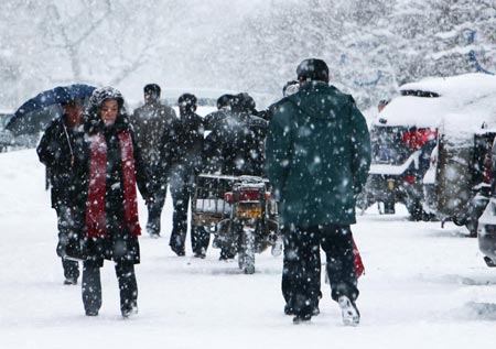 Residents walk in snow in Altay area in northwest China's Xinjiang Uygur Autonomous Region on February 5, 2009. A heavy snowfall hit Altay on Thursday. Local government has sent over 100 workers to the pasturing area to help herdsmen fight against chilliness.