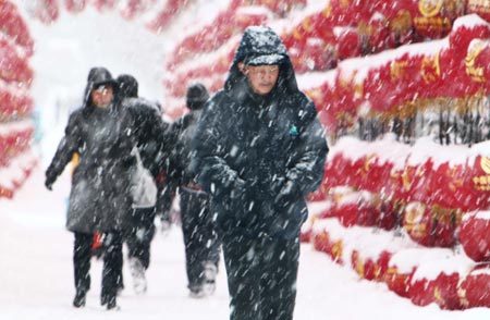 Residents walk in snow in Altay area in northwest China's Xinjiang Uygur Autonomous Region on February 5, 2009. A heavy snowfall hit Altay on Thursday. Local government has sent over 100 workers to the pasturing area to help herdsmen fight against chilliness.