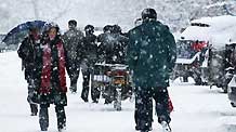 Residents walk in snow in Altay area in northwest China's Xinjiang Uygur Autonomous Region on February 5, 2009. A heavy snowfall hit Altay on Thursday. Local government has sent over 100 workers to the pasturing area to help herdsmen fight against chilliness.