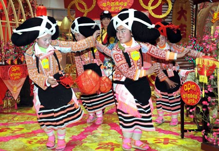 Girls of an old branch of the Miao ethnic group, dressed in traditional costumes with unique hair style like ox's horn, from southwest China's Guizhou Province dance in south China's Hong Kong, on February 5, 2009.