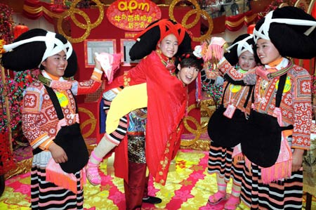 Girls of an old branch of the Miao ethnic group from southwest China's Guizhou Province dressed in traditional costumes with unique hair style like ox's horn, demonstrate traditional wedding ceremony in south China's Hong Kong, on February 5, 2009.