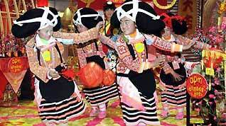 Girls of an old branch of the Miao ethnic group, dressed in traditional costumes with unique hair style like ox's horn, from southwest China's Guizhou Province dance in south China's Hong Kong, on February 5, 2009.