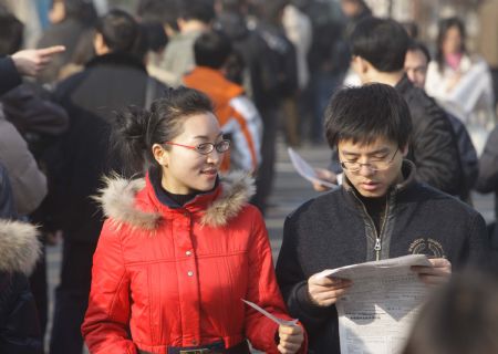 Job hunters look at job vacancy information at a job fair in Beijing, on February 5, 2009. Nearly 4,000 positions are offered by more than 300 companies at the job fair on Thursday.