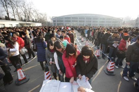 Job hunters receive materials with job vacancy information at a job fair in Beijing, on February 5, 2009. Nearly 4,000 positions are offered by more than 300 companies at the job fair on Thursday.