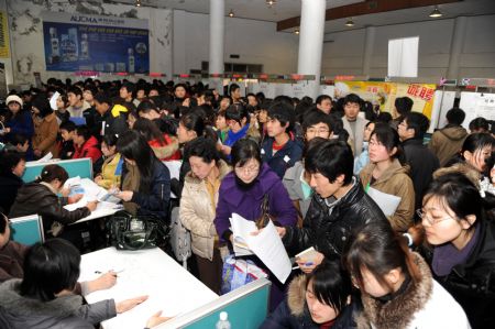 Job hunters hand in their resumes at a job fair for guaduates and postgraduates in Qingdao, east China's Shandong Province, on February 5, 2009. More than 30,000 graduates and postgraduates attended the job fair on Thursday. 