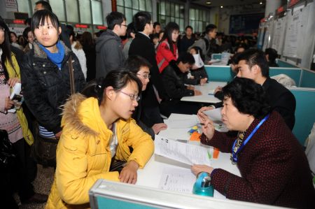 A job hunter talks with an employer at a job fair for guaduates and postgraduates in Qingdao, east China's Shandong Province, on February 5, 2009. More than 30,000 graduates and postgraduates attended the job fair on Thursday.