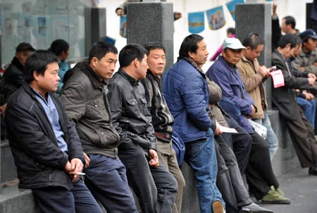 Migrant workers wait outside the Hangzhou Migrant Labour Force Market for jobs in Hangzhou, capital of east China's Zhejiang Province, on February 5, 2009. According to statistics of the market, the number of migrant workers looking for jobs in Hangzhou after Chinese traditional Spring Festival holidays is at the same level with those in 2008.