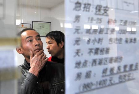 A migrant worker looks job information in the Hangzhou Migrant Labour Force Market for jobs in Hangzhou, capital of east China's Zhejiang Province, on February 5, 2009. According to the statistics of the market, the number of migrant workers looking for jobs in Hangzhou after the traditional Chinese Spring Festival is at the same level with those in 2008.
