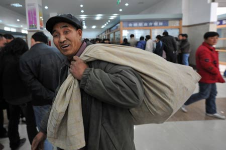 A migrant worker carrying baggage looks for job in the Hangzhou Migrant Labour Force Market for jobs in Hangzhou, capital of east China's Zhejiang Province, on February 5, 2009. According to statistics of the market, the number of migrant workers looking for jobs in Hangzhou after the traditional Chinese Spring Festival is at the same level with those in 2008.