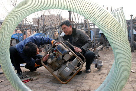 Members of a drought relief working team overhaul a water pump in Linfen, north China's Shanxi Province, on February 5, 2009. China raised the drought emergency class Thursday from level two to level one, the highest alert, in response to the worst drought to hit northern China in half a century, according to a State Council meeting.