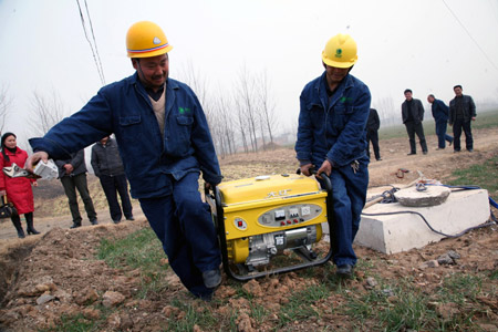 Workers of a power company install a generator to provide power for irrigating fields in Baizhuang Village of Baofeng County, central China's Henan Province, on February 5, 2009. 