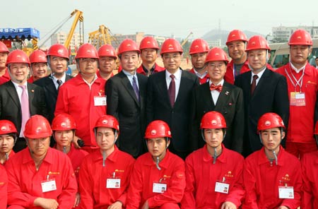 Chinese Vice Premier Li Keqiang (R3, 2nd row), Wang Yang (R4, 2nd row), member of the Political Bureau of the Central Committee of the Communist Party of China (CPC) and secretary of the CPC Guangdong Provincial Committee, and Donald Tsang Yam-kuen (R2, 2nd row), chief executive of the Hong Kong Special Administrative Region (HKSAR), pose with the buildersin Shenzhen City, south China's Guangdong Province, on February 7, 2009.