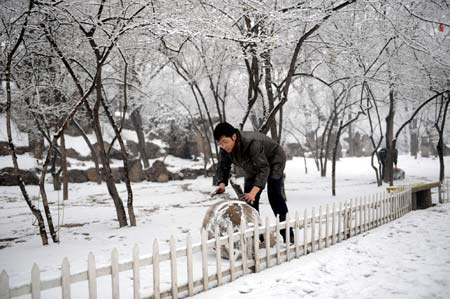 A man plays with snow in Taiyuan, capital of north China's Shanxi Province, on February 8, 2009. A snowfall hit Taiyuan on Sunday.