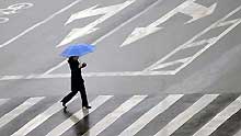 A resident walks in rain on Ma'anshan Road in Jinan, capital city of east China's Shandong Province, on February 8, 2009. A rainfall hit some areas of Shandong, partially easing the ongoing drought plaguing province.