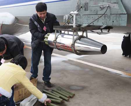 Workers equip the aircraft with catalystic silver iodide for the mission of artificial rainfall operations at Xinzheng International Airport in Zhengzhou, capital of central China's Henan Province, on February 8, 2009. A couple of 'Transport 7' aircraft of China's Air Force performed artificial rainfall operations in Huaibei of east China's Anhui Province, and Luoyang and Kaifeng of central China's Henan Province separately to relieve local drought on Sunday.