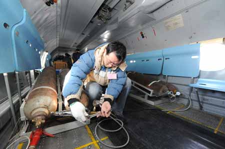 A crew member performs artificial rainfall operations on the aircraft over regions suffering from drought in central China's Henan Province, on February 8, 2009. A couple of 'Transport 7' aircraft of China's Air Force performed artificial rainfall operations in Huaibei of east China's Anhui Province, and Luoyang and Kaifeng of central China's Henan Province separately to relieve local drought on Sunday.