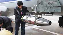 Workers equip the aircraft with catalystic silver iodide for the mission of artificial rainfall operations at Xinzheng International Airport in Zhengzhou, capital of central China's Henan Province, on February 8, 2009. A couple of 'Transport 7' aircraft of China's Air Force performed artificial rainfall operations in Huaibei of east China's Anhui Province, and Luoyang and Kaifeng of central China's Henan Province separately to relieve local drought on Sunday.