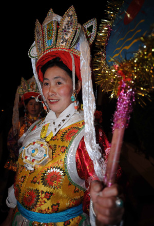 A Tibetan woman prepares to perform the Repa dance, a traditional Tibetan dance, in Tibetan autonomous prefecture of Diqing, southwest China's Yunnan Province, on February 7, 2009.