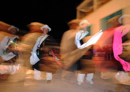 Tibetan residents perform the Tibetan Bonfire Dance, also known as the dance of 'Guozhuang', the traditional greeting dance of Tibetan and Qiang ethnic groups around the campfire, in Tibetan autonomous prefecture of Diqing, southwest China's Yunnan Province, on February 7, 2009. 