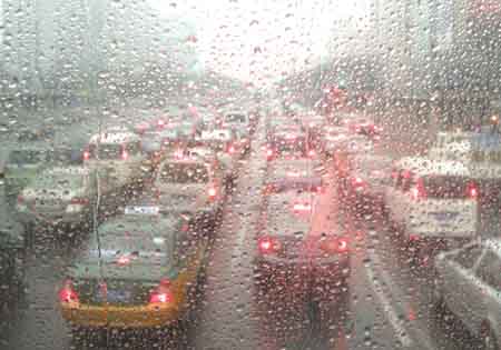 Photo taken on February 12, 2009 shows vehicles on a street seen through a piece of glass covered with raindrops in Beijing, China. Beijing welcomed its first rain in 110 days on Thursday morning, but experts say it was too little to end the city's lingering drought.