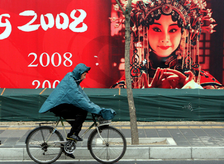 A man in raincoat rides on a road in Beijing, capital of China, on February 12, 2009. Beijing welcomed its first rain in 110 days on Thursday morning, but experts say it was too little to end the city's lingering drought.