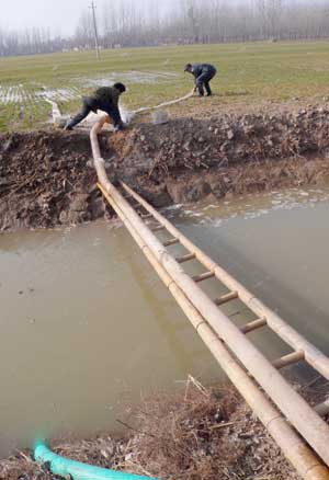 Farmers irrigate wheat land in Caoxian County in Heze City, east China's Shandong Province, on February 10, 2009. Thirty floodgates are opened in Shandong Province to draw water from the Yellow River to irrigate the wheat fields in fighting against the drought and reducing damages.